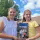 Evi en Lisa poseren met het boek 'Samen sta je sterk'